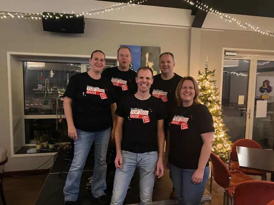 Team in zwarte shirts bij de kerstboom