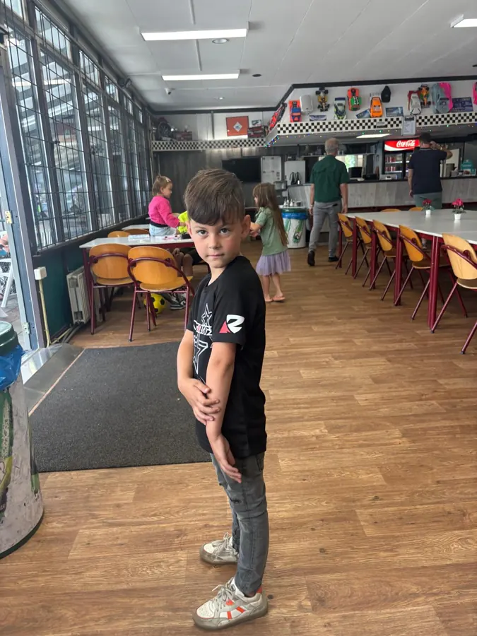 Jongen in zwart shirt met logo