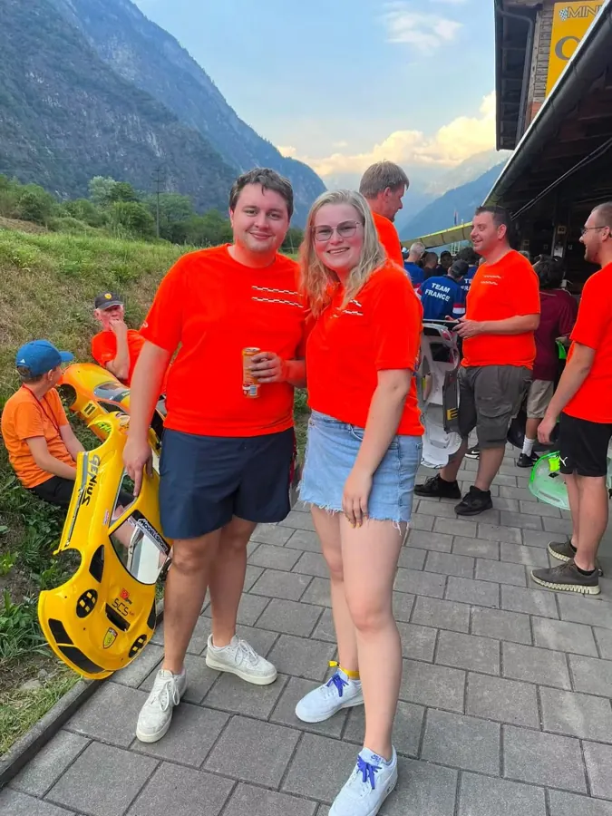 Team in oranje shirts bij een race in de bergen