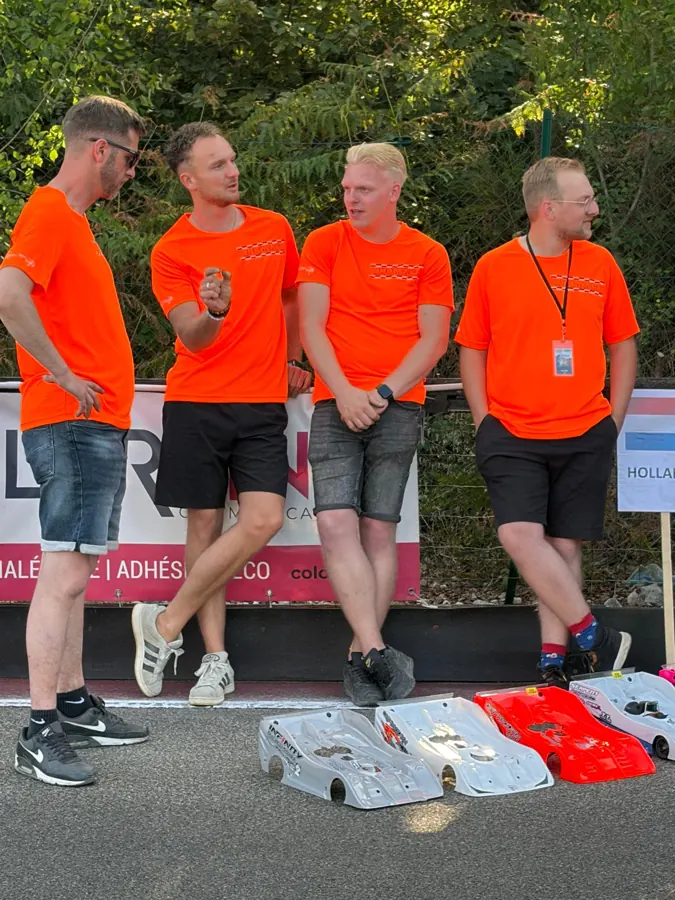Vier teamleden in oranje teamshirts