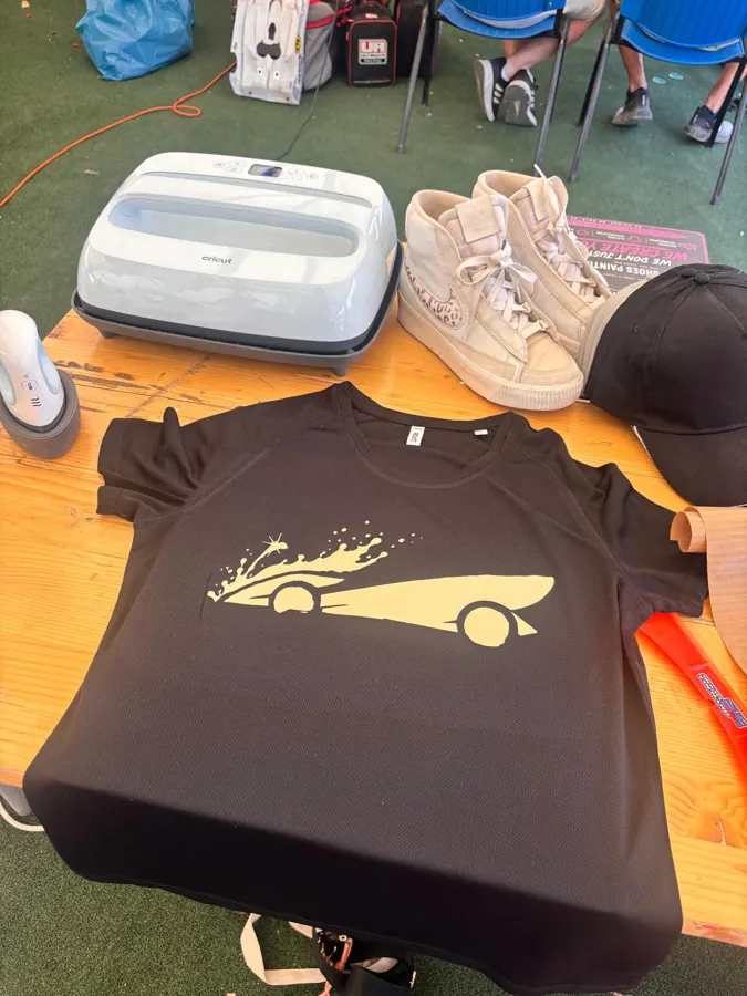 Zwart shirt met raceauto-print naast de heatpress