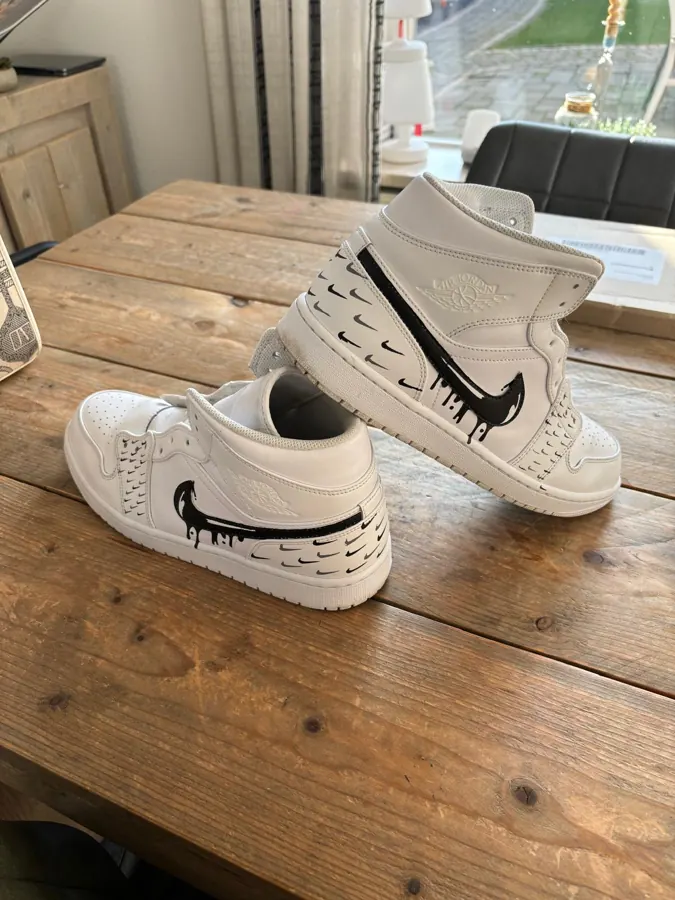 Witte sneakers met zwart drip-logo
