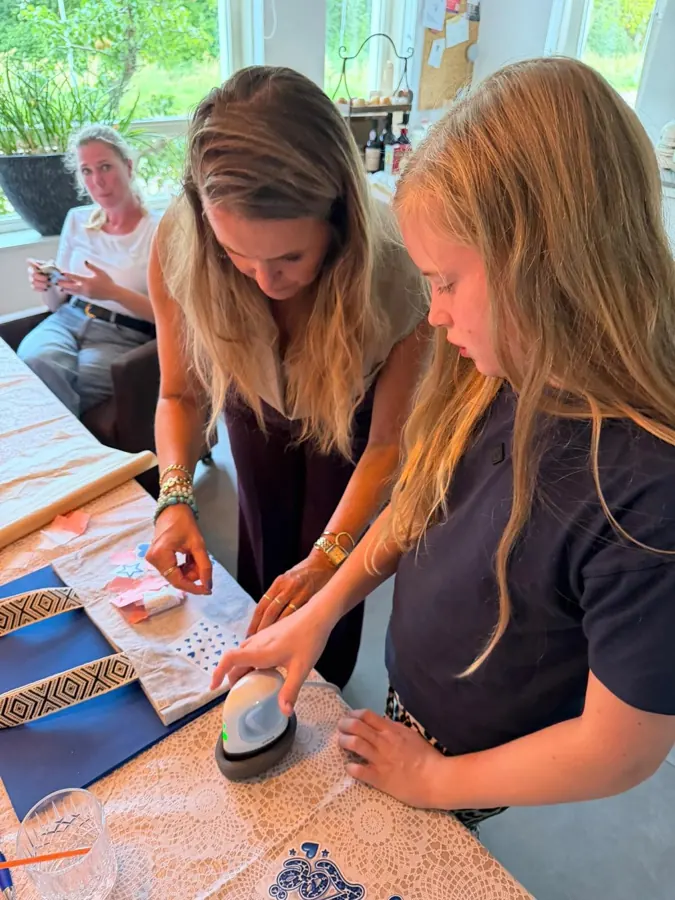 Kinderen strijken een ontwerp op hun tas tijdens de workshop