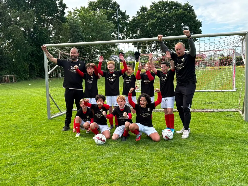 Voetbalteam in custom kampioensshirts bij het doel