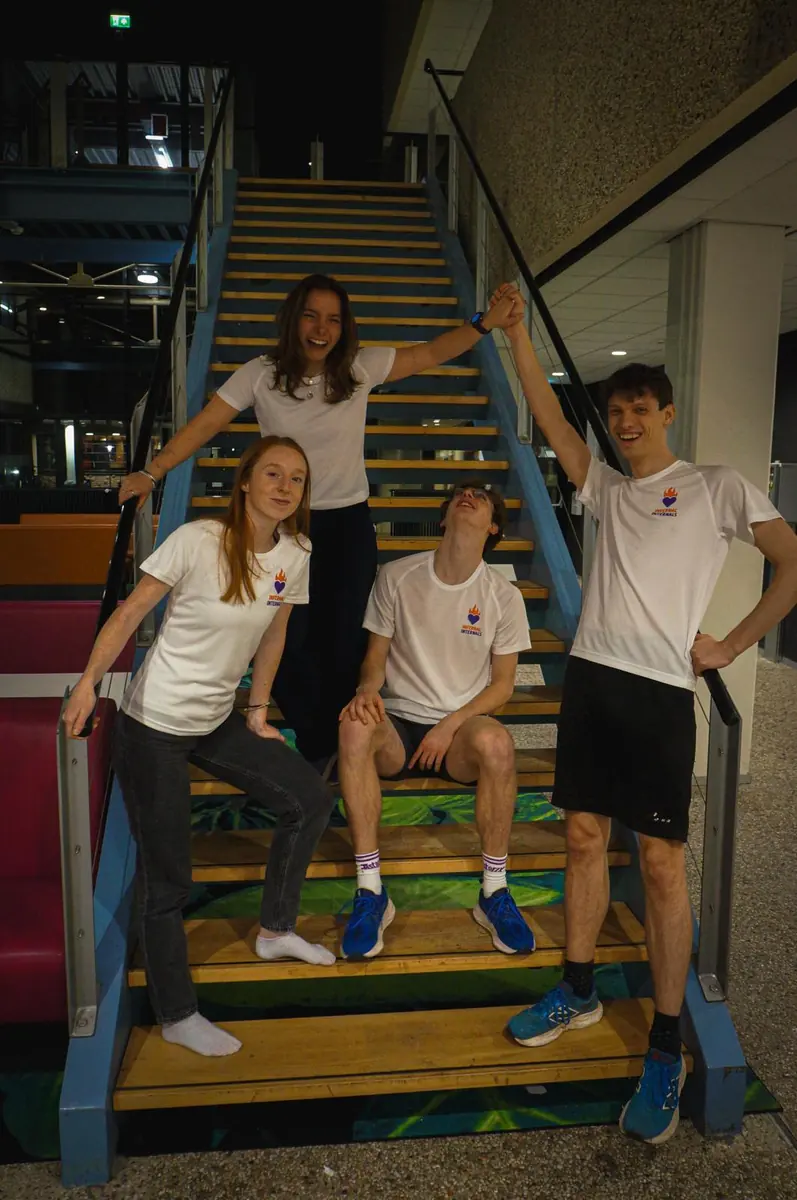 Team in witte shirts op de trap