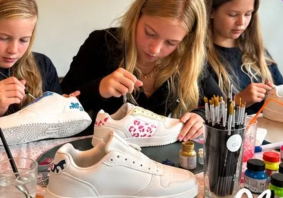 Kinderen schilderen hun eigen sneakers tijdens een workshop van Cusz for You